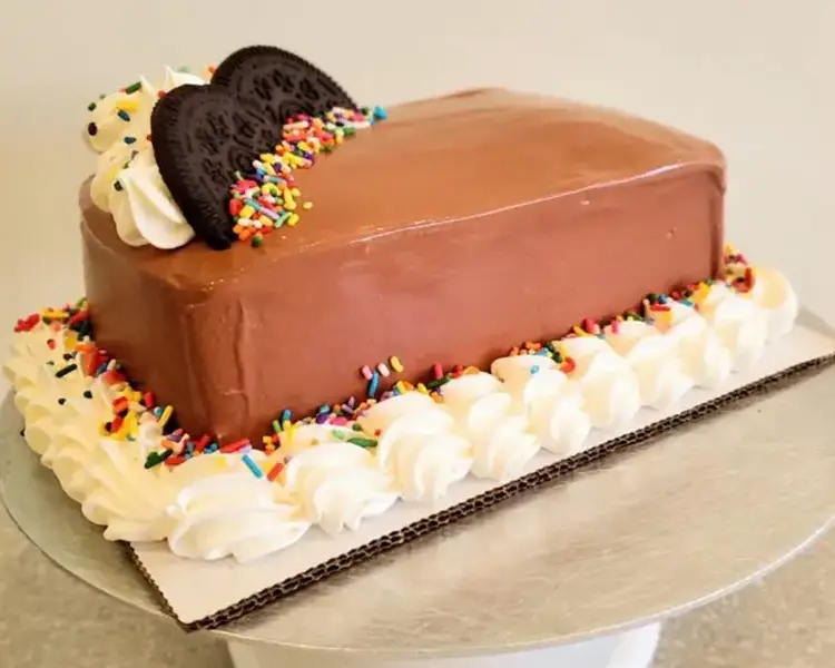 Rectangle cake with brown icing, white piping around the edge, 2 oreos on top